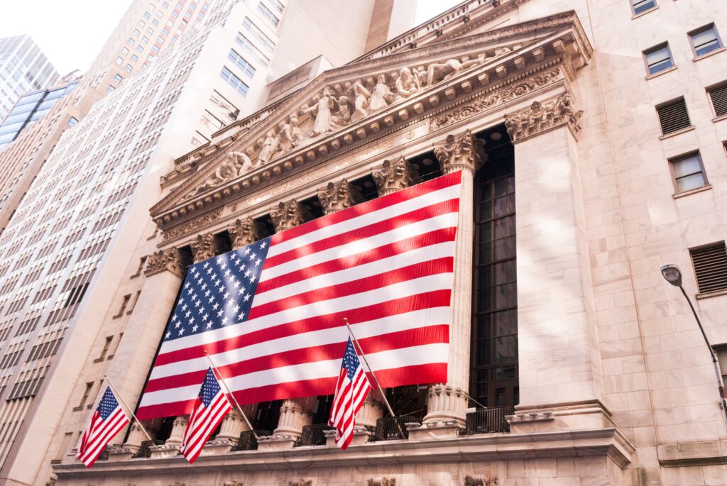 La facciata del New York Stock Exchange con la bandiera americana a Wall Street