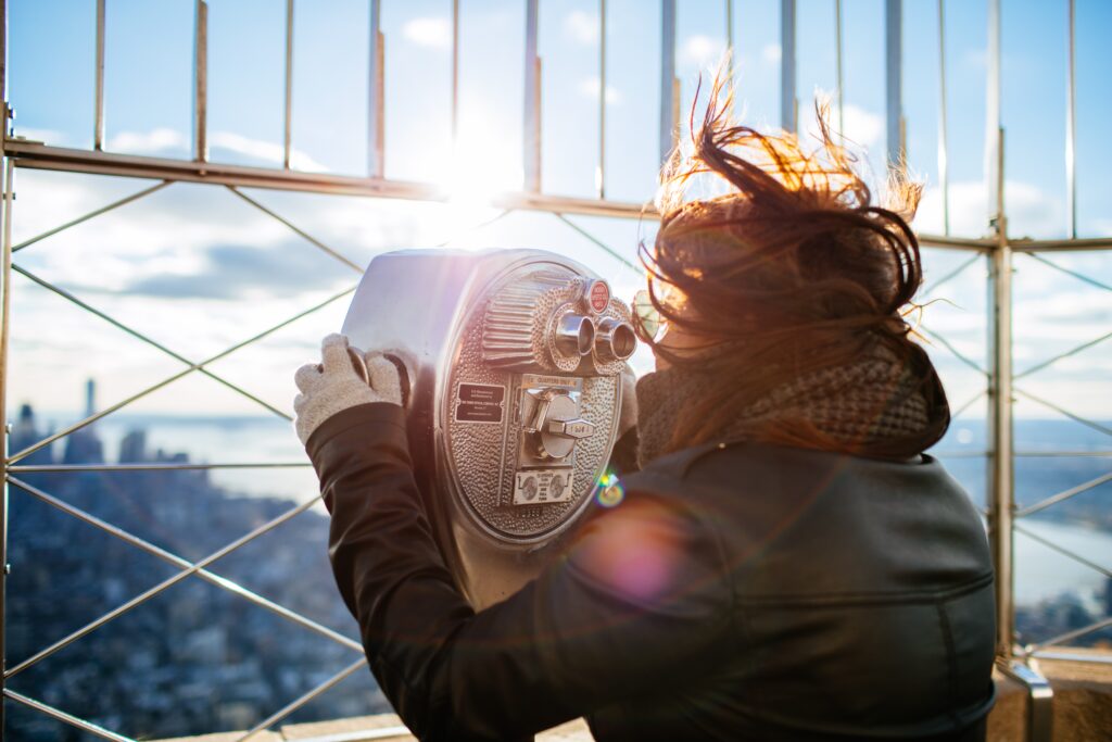 Biglietti Empire State Building di New York: Visitatrice al binocolo panoramico sulla terrazza